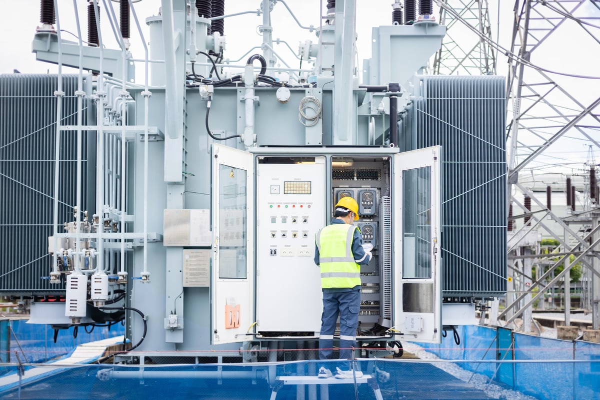 Ingeniero inspeccionando una subestación eléctrica de alta tensión