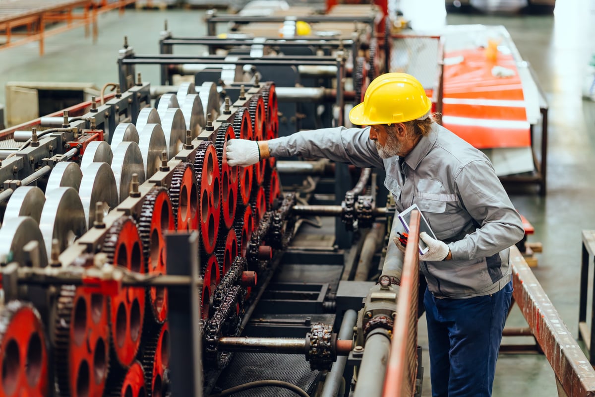 Técnico verificando maquinaria industrial en una planta de metal